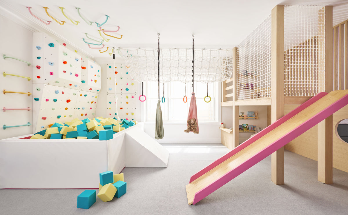 Indoor foam pit in a kids' playroom with a slide and hanging swings