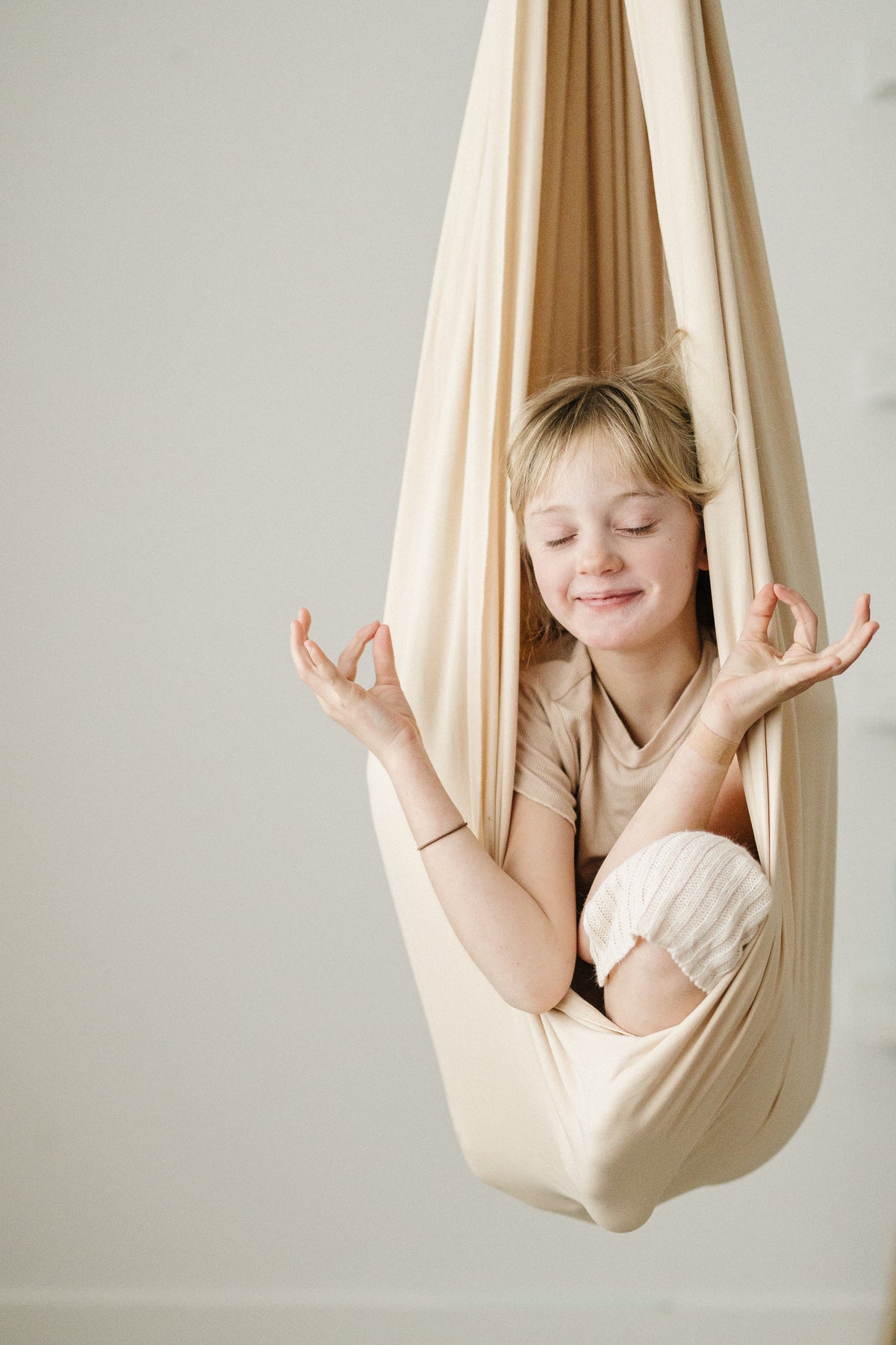 Child meditating in Oat double-layer sensory swing for gentle compression and sensory input