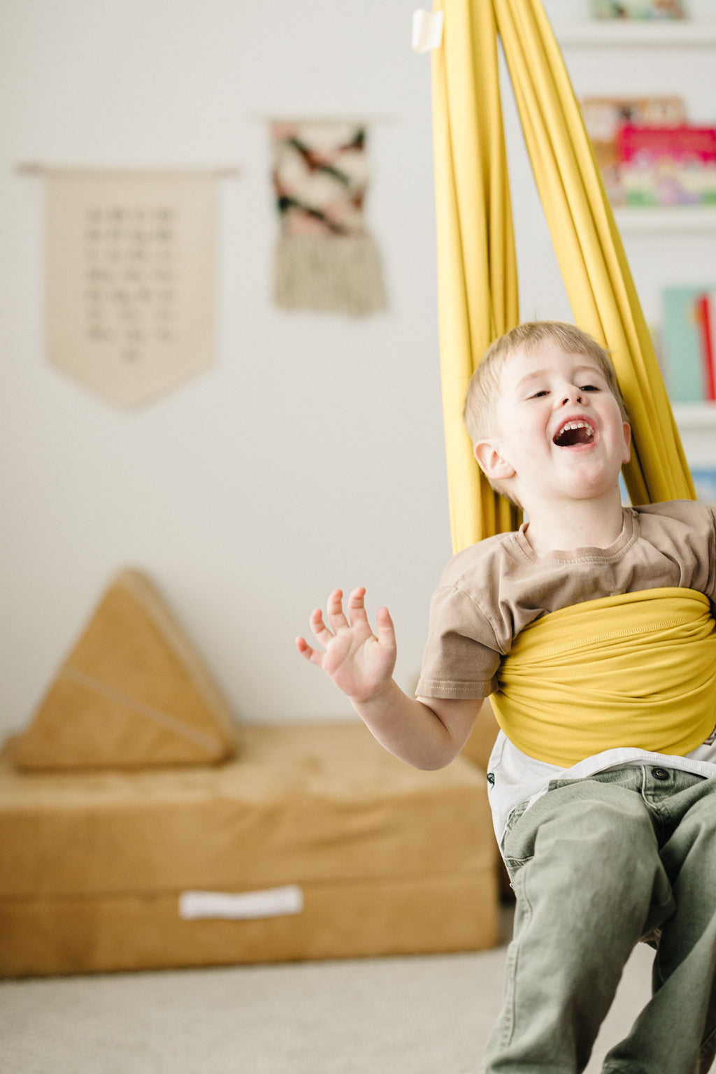 Child swinging in Retro Pineapple sensory swing for active indoor play