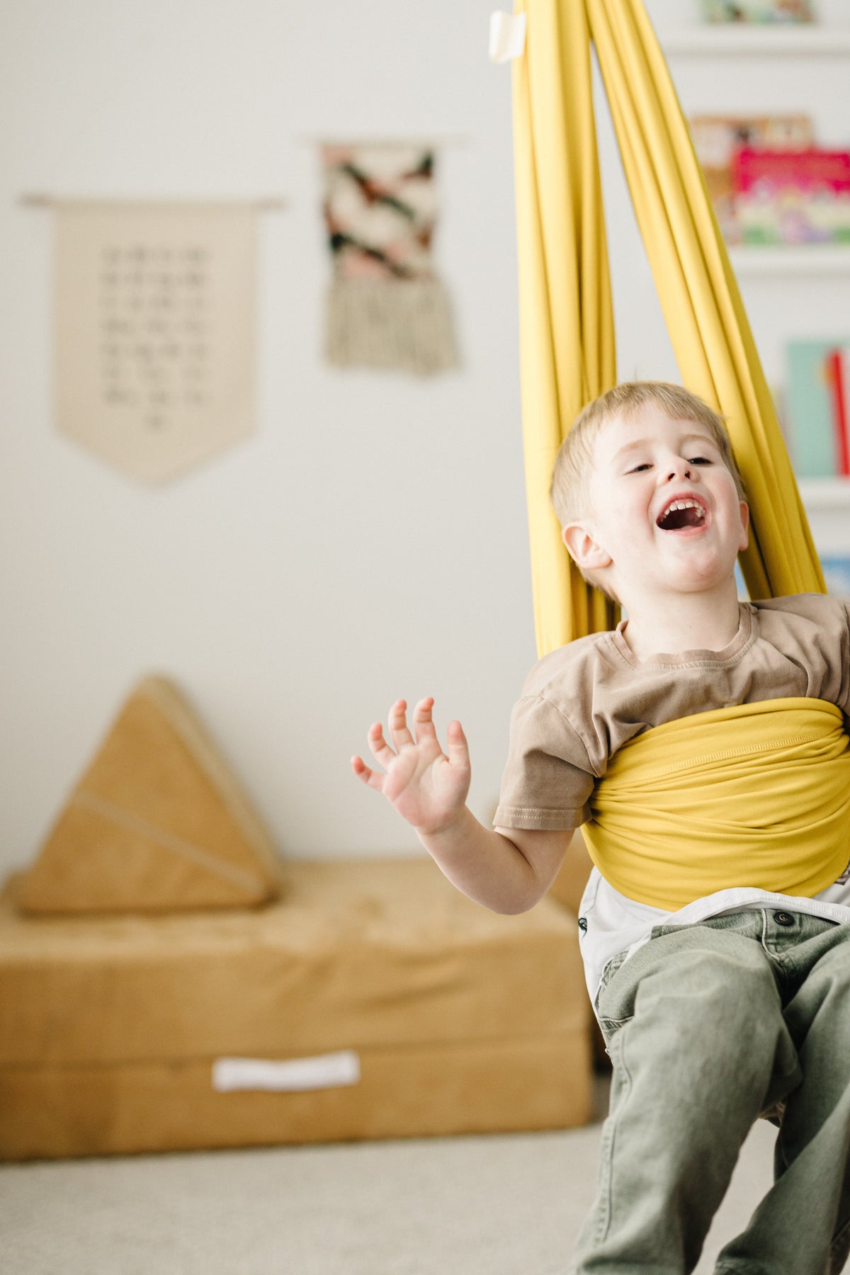 Child swinging in Retro Pineapple sensory swing for active indoor play