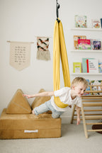 Child swinging on stomach in Retro Pineapple sensory swing for sensory play 