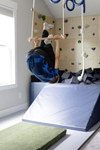 Child upside down on trapeze bar