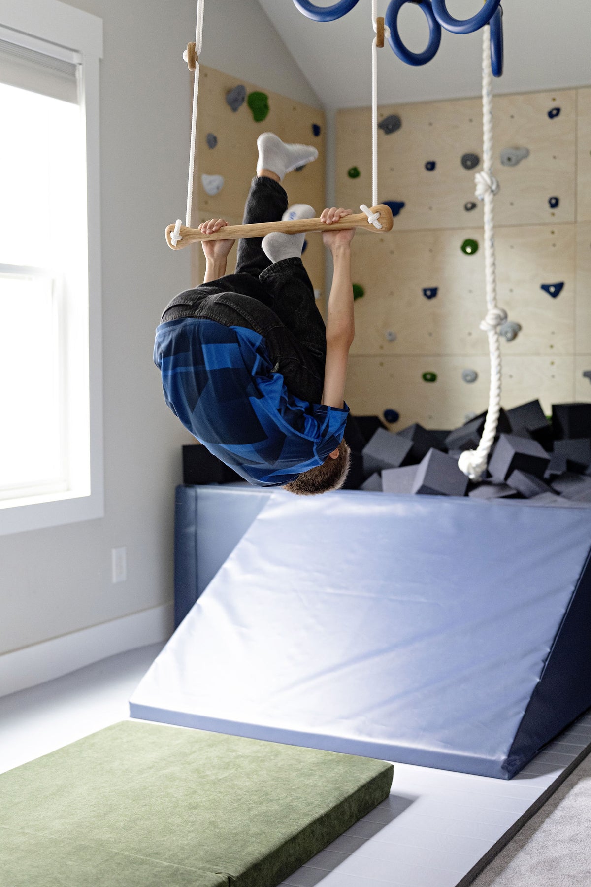 Child upside down on trapeze bar