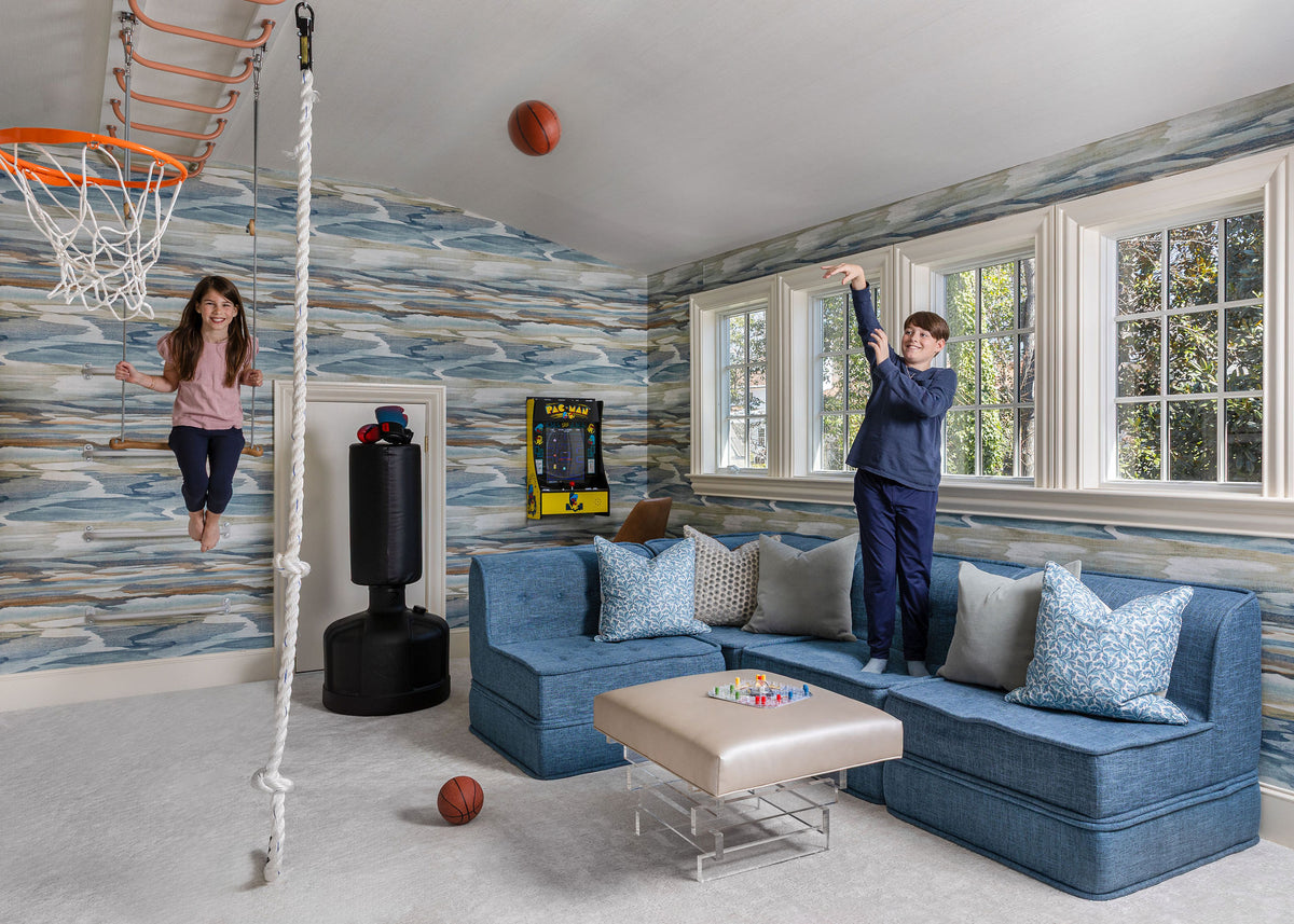 Girl swinging on trapeze bar while boy shoots basketball
