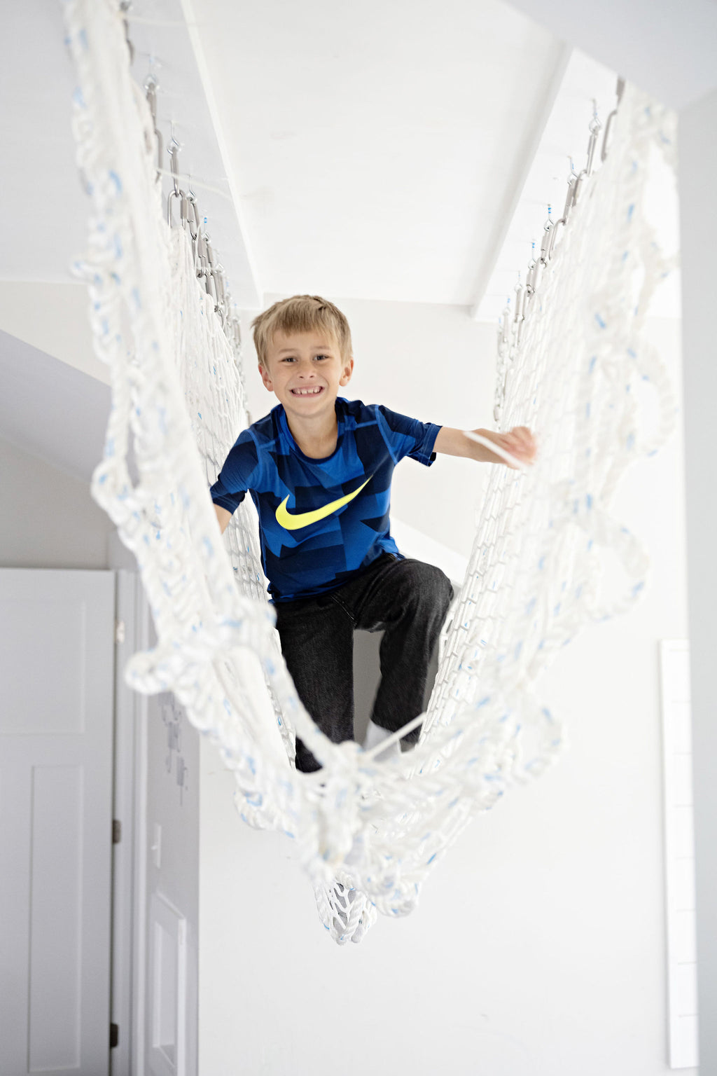 Child climbing through cargo net rope tunnel 
