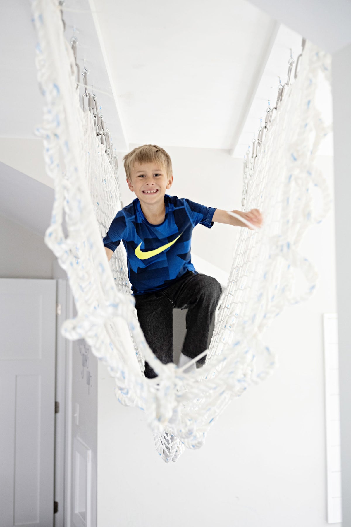 Child climbing through cargo net rope tunnel 