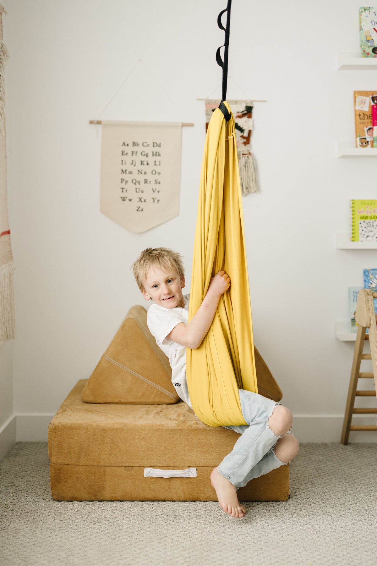 Child sitting in Retro Pineapple sensory swing in a playroom