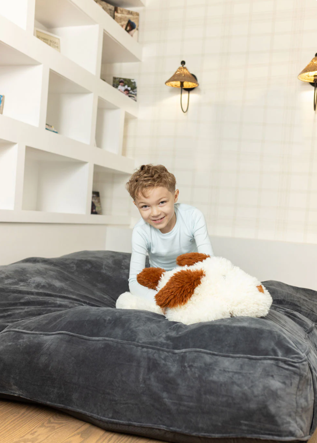 Child on gray sensory landing  pad in kids bedroom
